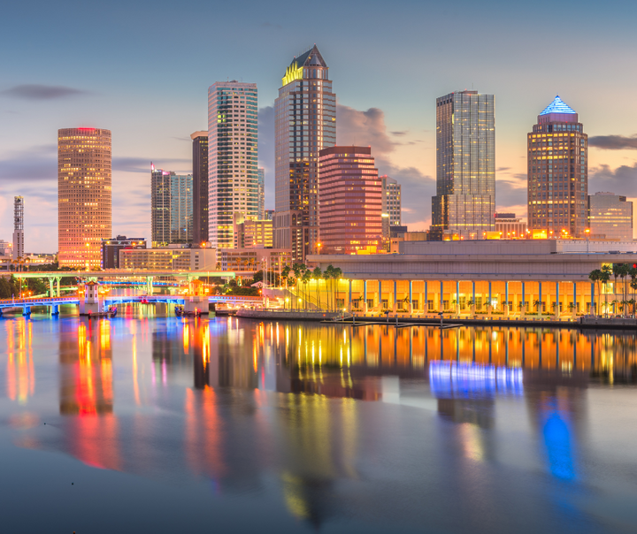 Aerial view of a Florida Gulf Coast causeway at dusk representing the $3.2 billion boom triggered by California's exodus to Tampa, Sarasota, and Naples